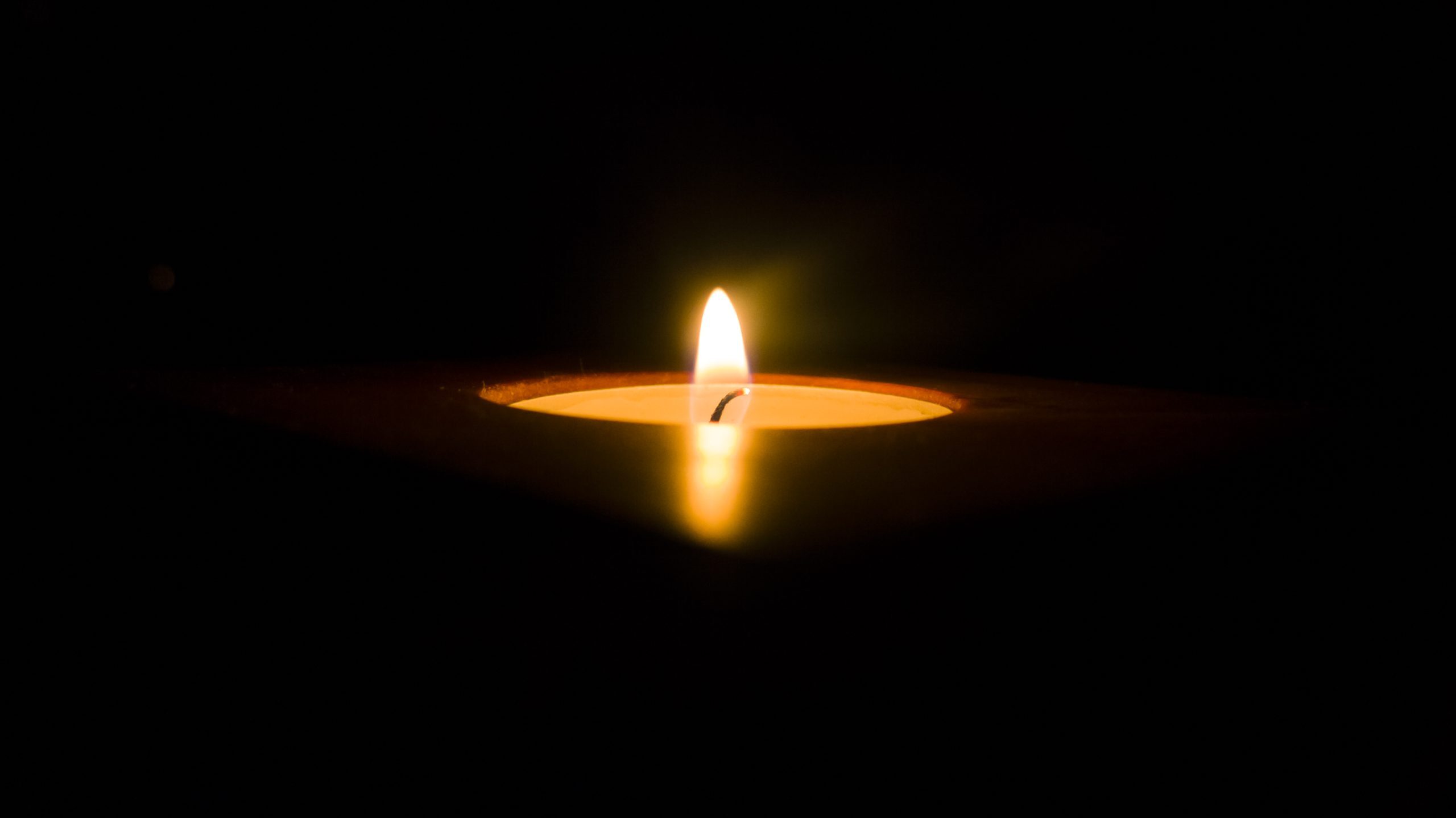 A single lit candle in a dark environment, its flame at the center, gently illuminating the shadows—reflecting the warmth and comfort found at Sholom Senior Living. A single lit candle in a dark environment, its flame at the center, gently illuminating the shadows—reflecting the warmth and comfort found at Sholom Senior Living.